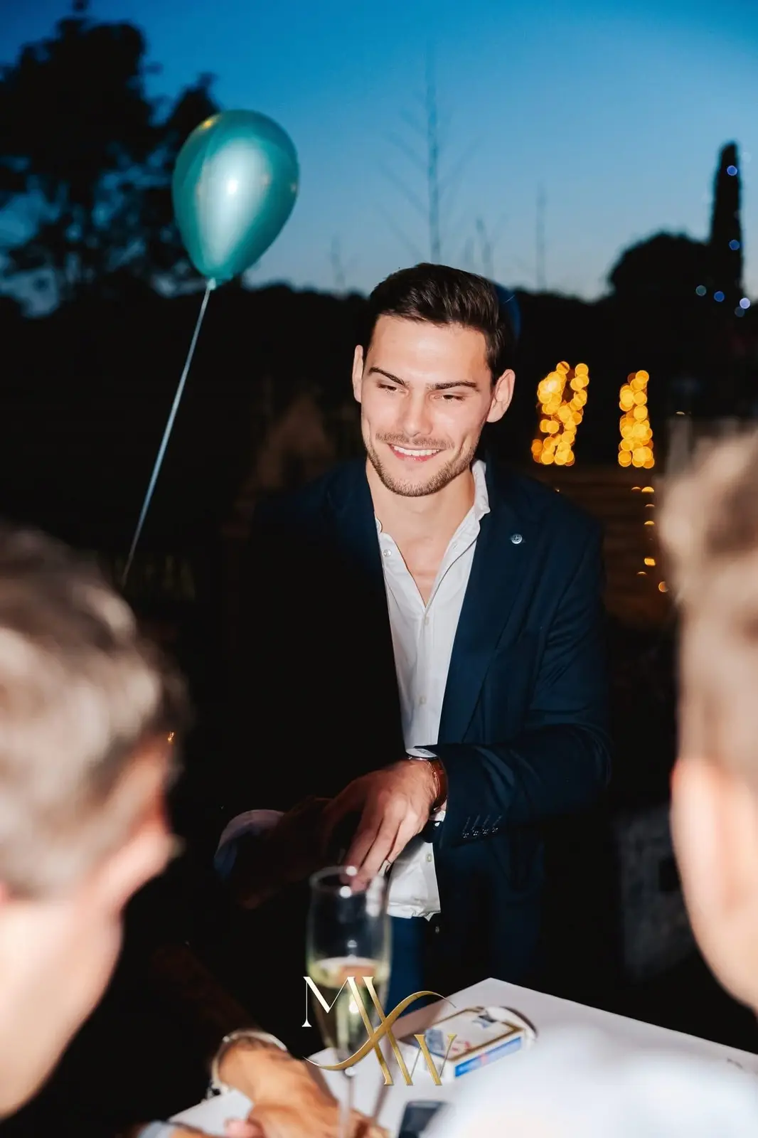 Gasten volgen een interactieve kaarttruc tijdens een sfeervol avondfeest